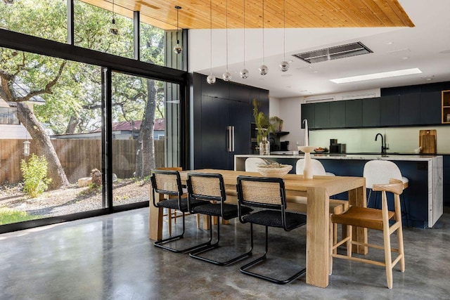 dining space featuring finished concrete floors and a high ceiling