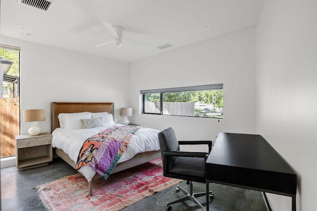 bedroom with an office area, finished concrete floors, and ceiling fan