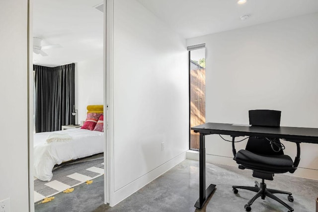 home office with finished concrete flooring and baseboards