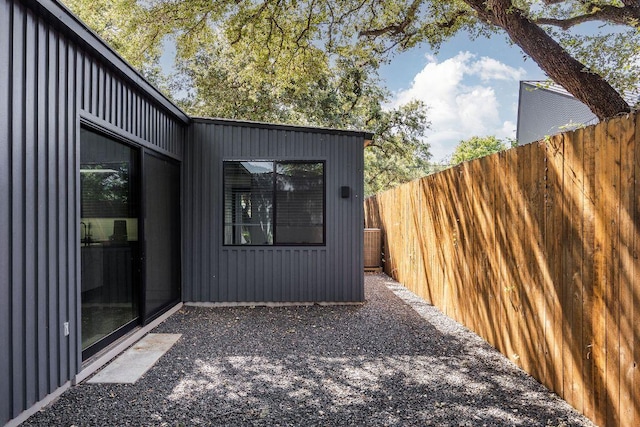 view of property exterior featuring fence and board and batten siding