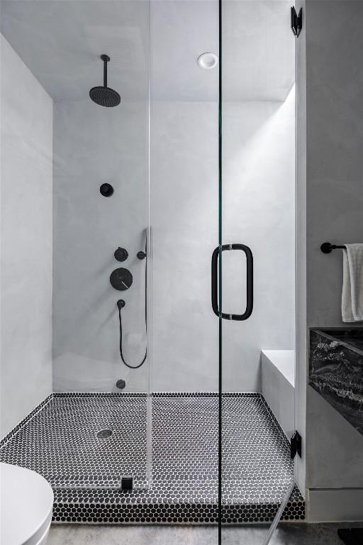 full bathroom featuring a shower stall, toilet, and tile patterned flooring