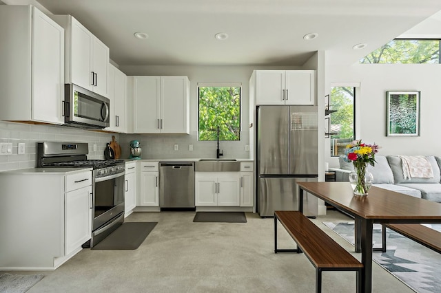 1405 Perez St Unit 2, Austin, TX 78721 - kitchen featuring stainless steel appliances, light countertops, tasteful backsplash, white cabinets, and recessed lighting