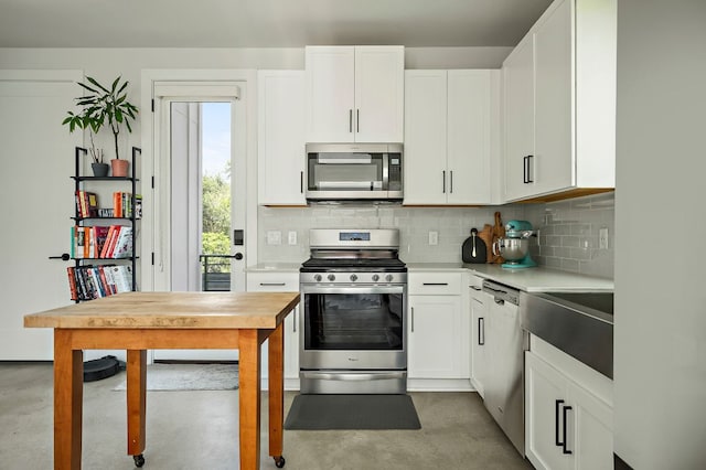 kitchen featuring appliances with stainless steel finishes, finished concrete flooring, and light countertops