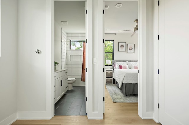 hallway featuring light wood-style floors and baseboards