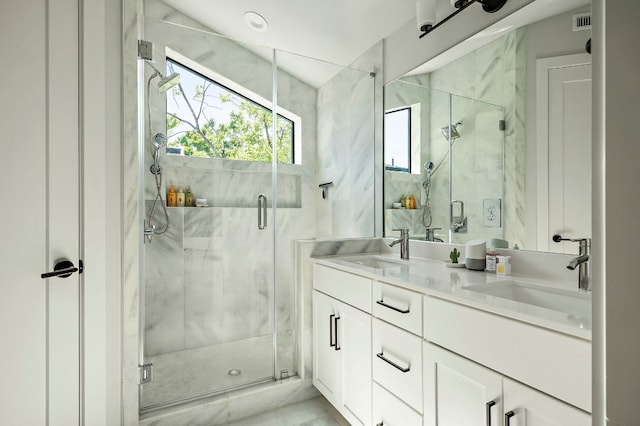 full bath featuring a marble finish shower and double vanity