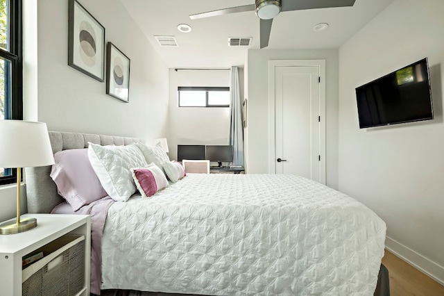 bedroom with wood finished floors, baseboards, and a ceiling fan