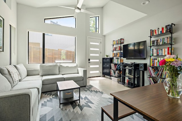 living area with ceiling fan, a towering ceiling, and recessed lighting