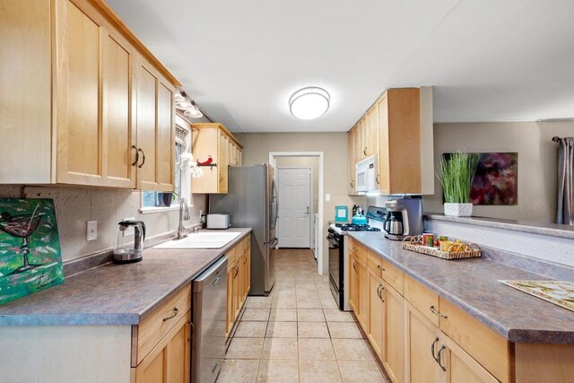 8017 Gault St, Austin, TX 78757 - kitchen with appliances with stainless steel finishes, light brown cabinets, light tile patterned floors, dark countertops, and a peninsula