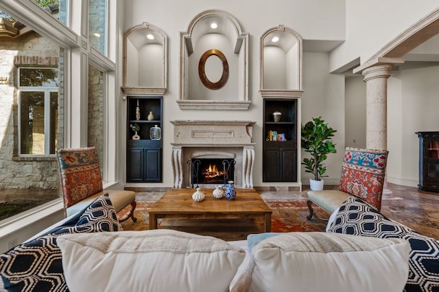 401 Brooks Hollow Rd, Lakeway, TX 78734 - living area featuring a lit fireplace, decorative columns, and baseboards