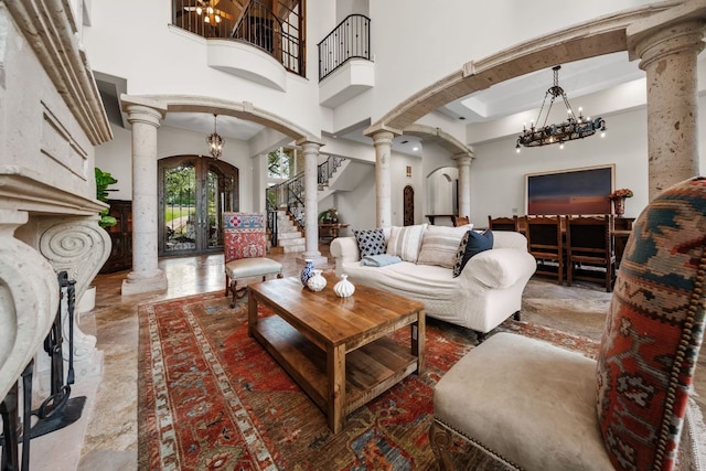 401 Brooks Hollow Rd, Lakeway, TX 78734 - living room with decorative columns, arched walkways, a chandelier, a towering ceiling, and marble tiled flooring
