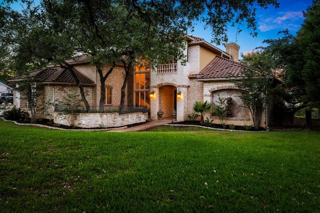 401 Brooks Hollow Rd, Lakeway, TX 78734 - mediterranean / spanish home featuring a chimney, a balcony, a tiled roof, and stone siding
