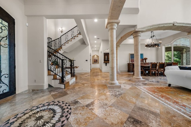 foyer featuring decorative columns, recessed lighting, a chandelier, arched walkways, and stairs