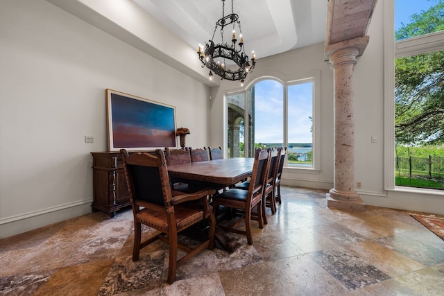 401 Brooks Hollow Rd, Lakeway, TX 78734 - dining area with stone tile floors, ornate columns, a chandelier, and baseboards