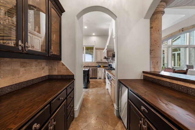 401 Brooks Hollow Rd, Lakeway, TX 78734 - bar area featuring arched walkways, backsplash, dishwasher, recessed lighting, and light stone finish floors