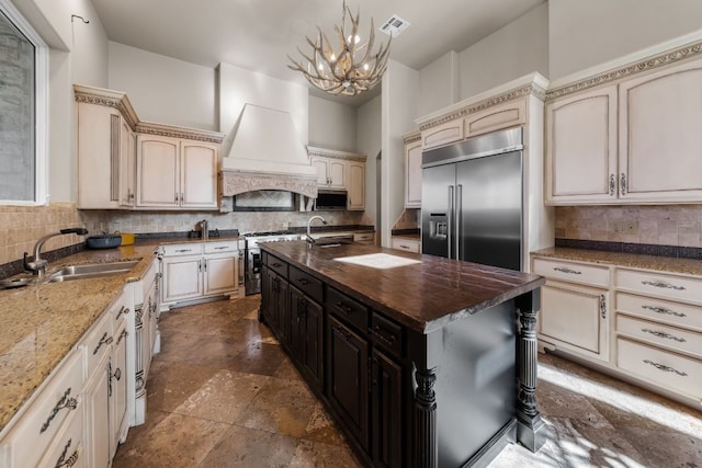 401 Brooks Hollow Rd, Lakeway, TX 78734 - kitchen featuring cream cabinetry, stainless steel appliances, a sink, and a chandelier