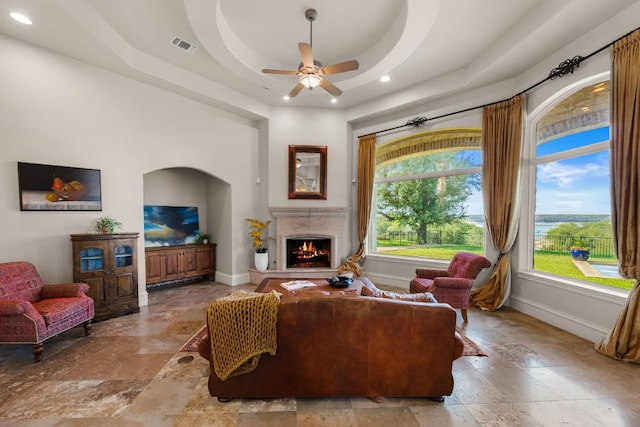 401 Brooks Hollow Rd, Lakeway, TX 78734 - living area featuring stone tile floors, baseboards, a warm lit fireplace, a ceiling fan, and recessed lighting