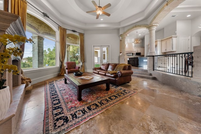 living area with ceiling fan, ornate columns, a raised ceiling, recessed lighting, and arched walkways