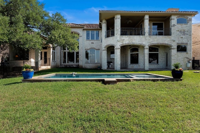 401 Brooks Hollow Rd, Lakeway, TX 78734 - rear view of house featuring a balcony, a ceiling fan, a lawn, stone siding, and a tile roof