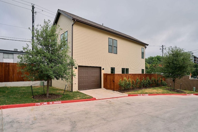 2209 Woodland Ave Unit 101, Austin, TX 78741 - view of home's exterior with fence, an attached garage, and concrete driveway