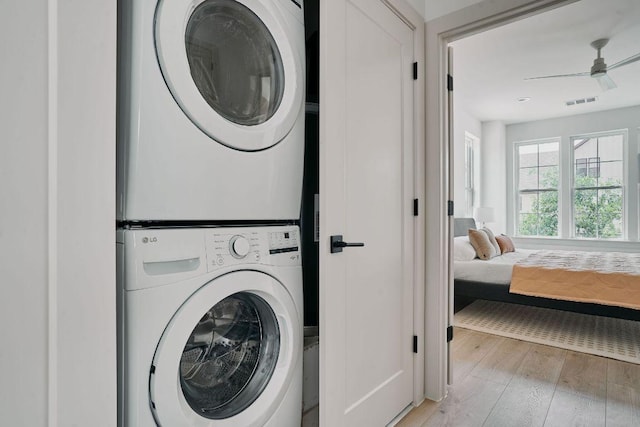 2209 Woodland Ave Unit 101, Austin, TX 78741 - washroom featuring stacked washer and clothes dryer, light wood-style flooring, and a ceiling fan