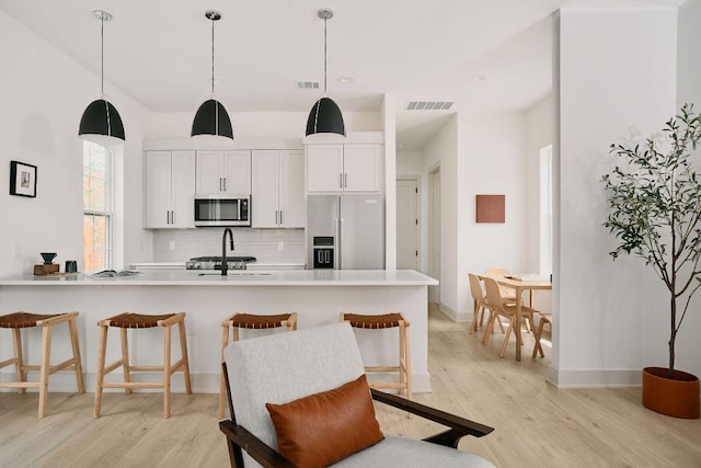 2209 Woodland Ave Unit 101, Austin, TX 78741 - kitchen with appliances with stainless steel finishes, decorative backsplash, a breakfast bar, and a sink