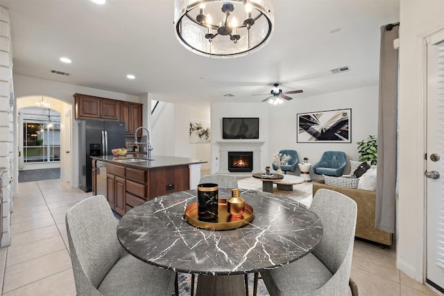 199 Limestone Trl, Austin, TX 78737 - dining space with light tile patterned flooring, ceiling fan, arched walkways, recessed lighting, and a warm lit fireplace