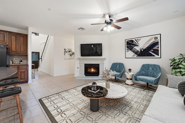 199 Limestone Trl, Austin, TX 78737 - living room featuring ceiling fan, stairway, a lit fireplace, and light tile patterned flooring