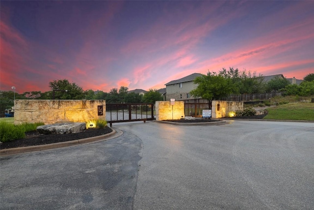 199 Limestone Trl Unit 73, Austin, TX 78737 - view of asphalt road with a gate, curbs, and a gated entry