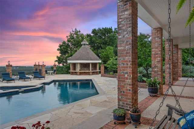 12 Hedge Ln, Austin, TX 78746 - pool at dusk featuring a patio, a pool with connected hot tub, a gazebo, and an outbuilding