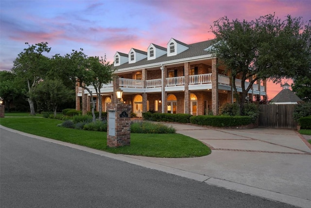 12 Hedge Ln, Austin, TX 78746 - view of front of house featuring a balcony, brick siding, curved driveway, and a gate