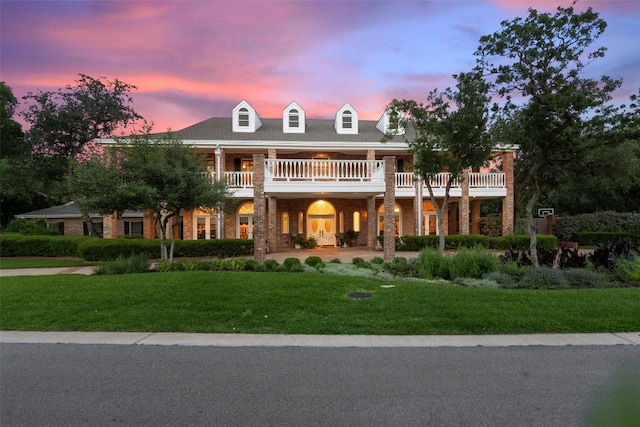 12 Hedge Ln, Austin, TX 78746 - view of front of home with a balcony, a front yard, and brick siding