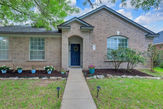 view of front of property with brick siding and a front lawn