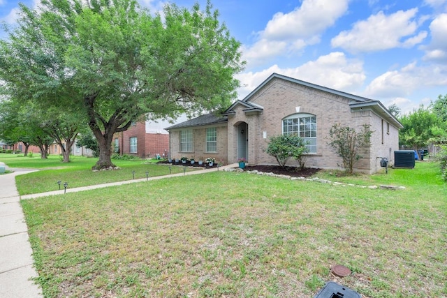 ranch-style home featuring brick siding, cooling unit, and a front yard