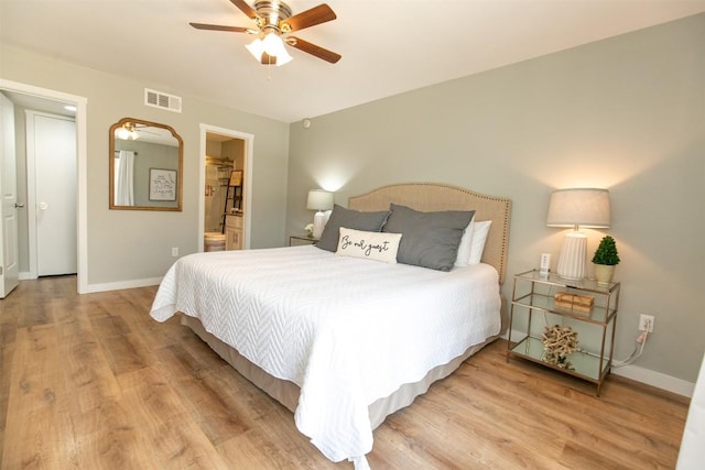 104 Cove E Unit 103, Horseshoe Bay, TX 78657 - bedroom with wood finished floors, baseboards, ensuite bath, and ceiling fan