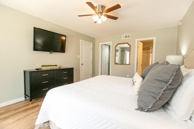 104 Cove E Unit 103, Horseshoe Bay, TX 78657 - bedroom featuring light wood-style floors, baseboards, ceiling fan, and connected bathroom