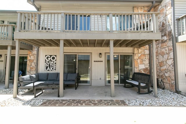 104 Cove E Unit 103, Horseshoe Bay, TX 78657 - back of house featuring a balcony, an outdoor hangout area, stone siding, and a patio