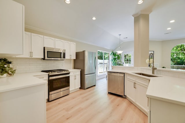 kitchen with appliances with stainless steel finishes, a sink, decorative backsplash, light wood-type flooring, and white cabinetry
