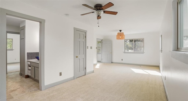 13918 Hummingbird Ln, Austin, TX 78732 - unfurnished living room featuring light colored carpet, a ceiling fan, and baseboards