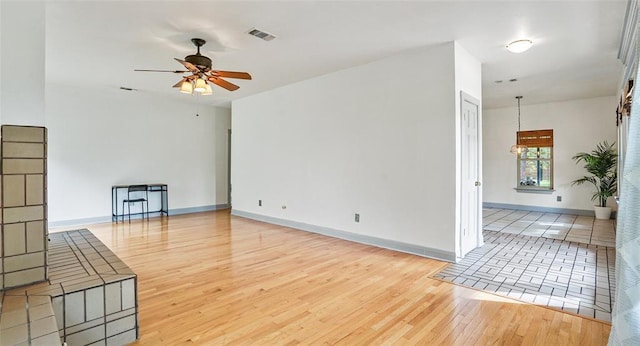 13918 Hummingbird Ln, Austin, TX 78732 - unfurnished living room featuring ceiling fan, wood finished floors, and baseboards
