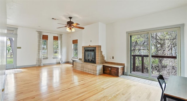 13918 Hummingbird Ln, Austin, TX 78732 - unfurnished living room with light wood finished floors, a fireplace, and ceiling fan