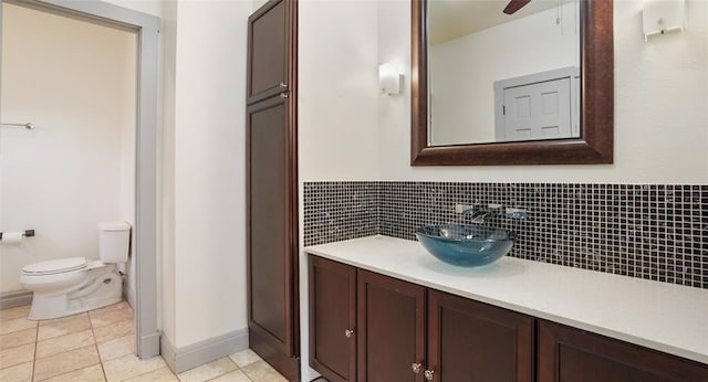 13918 Hummingbird Ln, Austin, TX 78732 - bathroom with vanity, tasteful backsplash, baseboards, toilet, and tile patterned flooring