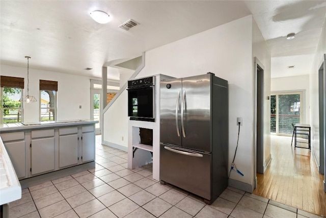 13918 Hummingbird Ln, Austin, TX 78732 - kitchen featuring freestanding refrigerator, oven, light tile patterned floors, baseboards, and hanging light fixtures