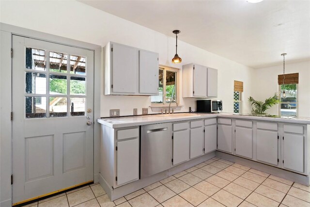 13918 Hummingbird Ln, Austin, TX 78732 - kitchen with stainless steel appliances, light tile patterned flooring, light countertops, hanging light fixtures, and a sink