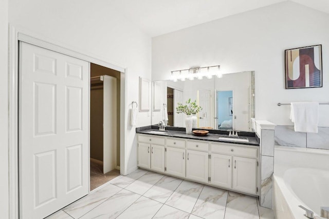 bathroom with ensuite bathroom, double vanity, a garden tub, and marble finish floors