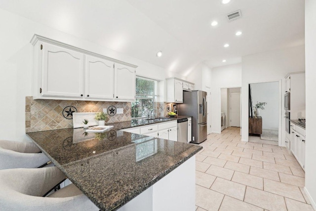 7403 Ponoma Trl, Austin, TX 78749 - kitchen with a peninsula, dark stone countertops, a sink, recessed lighting, and tasteful backsplash
