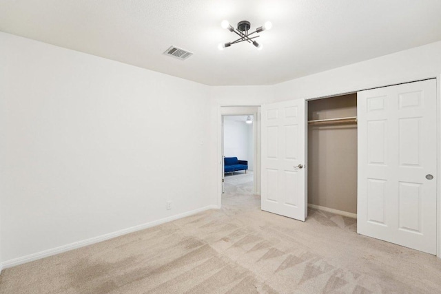 unfurnished bedroom featuring light carpet, baseboards, and a closet