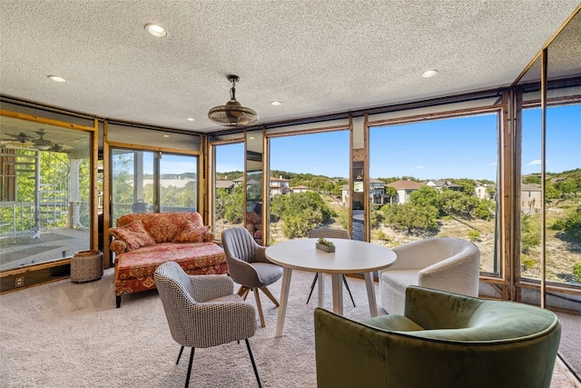 sunroom with a textured ceiling, carpet floors, recessed lighting, and healthy amount of natural light