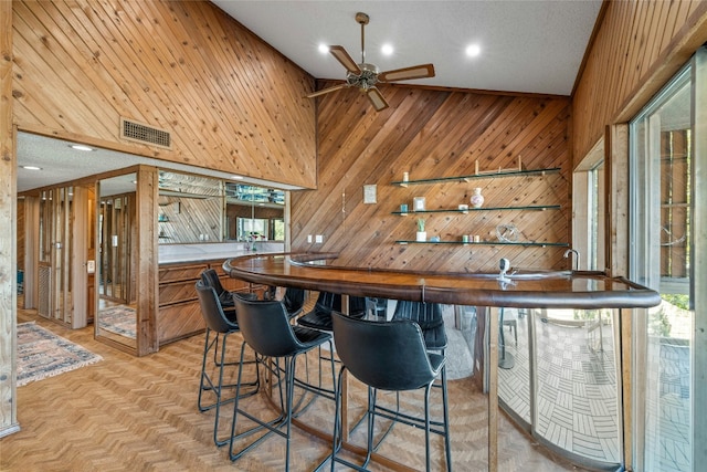 indoor wet bar featuring wooden walls, ceiling fan, and recessed lighting