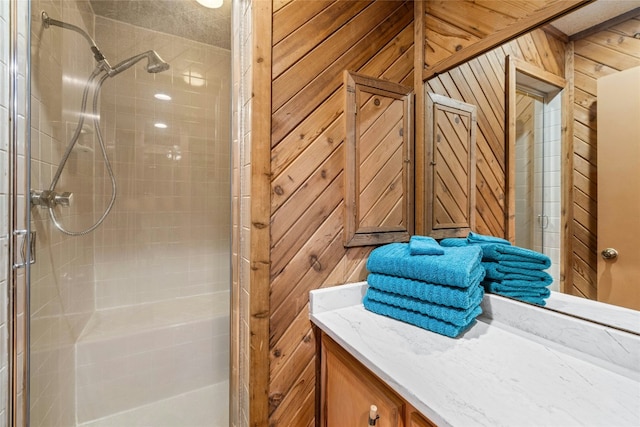 bathroom with a stall shower, wooden walls, and vanity