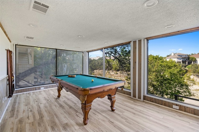 game room with a textured ceiling, floor to ceiling windows, light wood finished floors, and billiards table